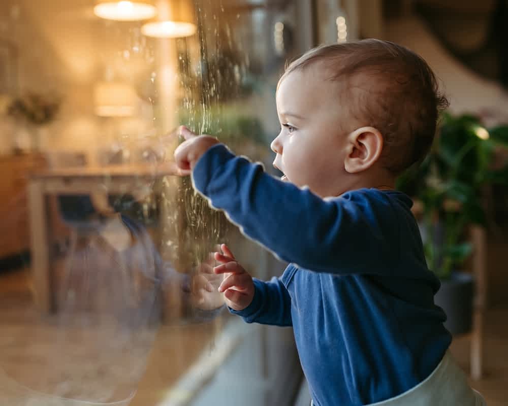 A toddler making marks on an internal french door