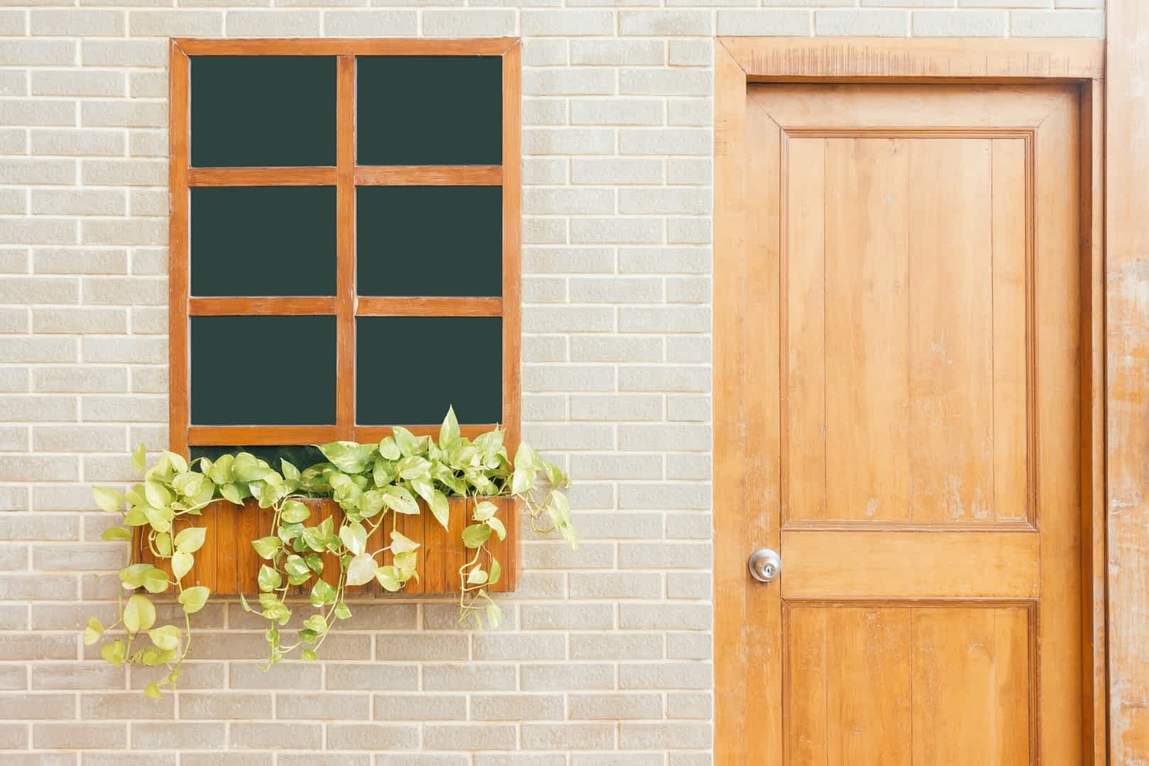 asset photo of an oak cottage door next to a window with flowers