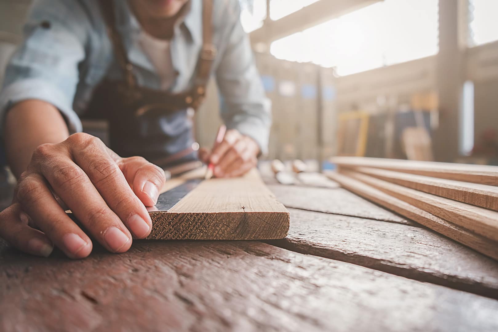Featured image of a man measuring a plank of wood to cut.