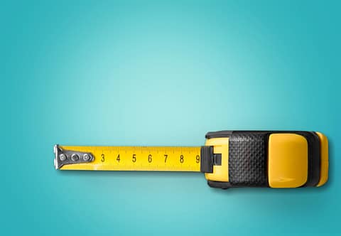 yellow tape measure on a turquoise blue background