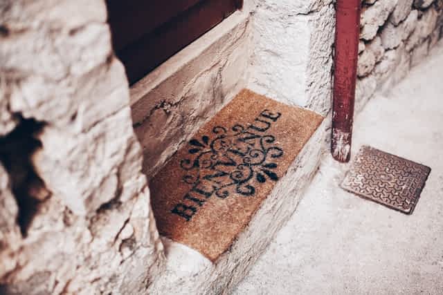 husk doormat that reads bienvenue upon a white brick doorstep
